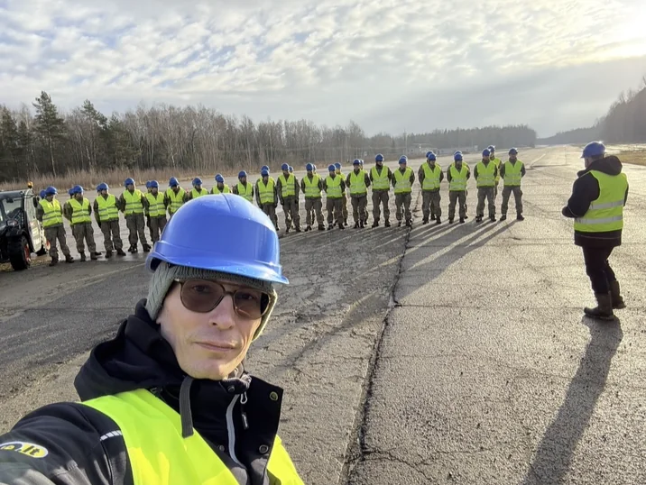 Praktinių mokymų dalyviai prie mokymo technikos.